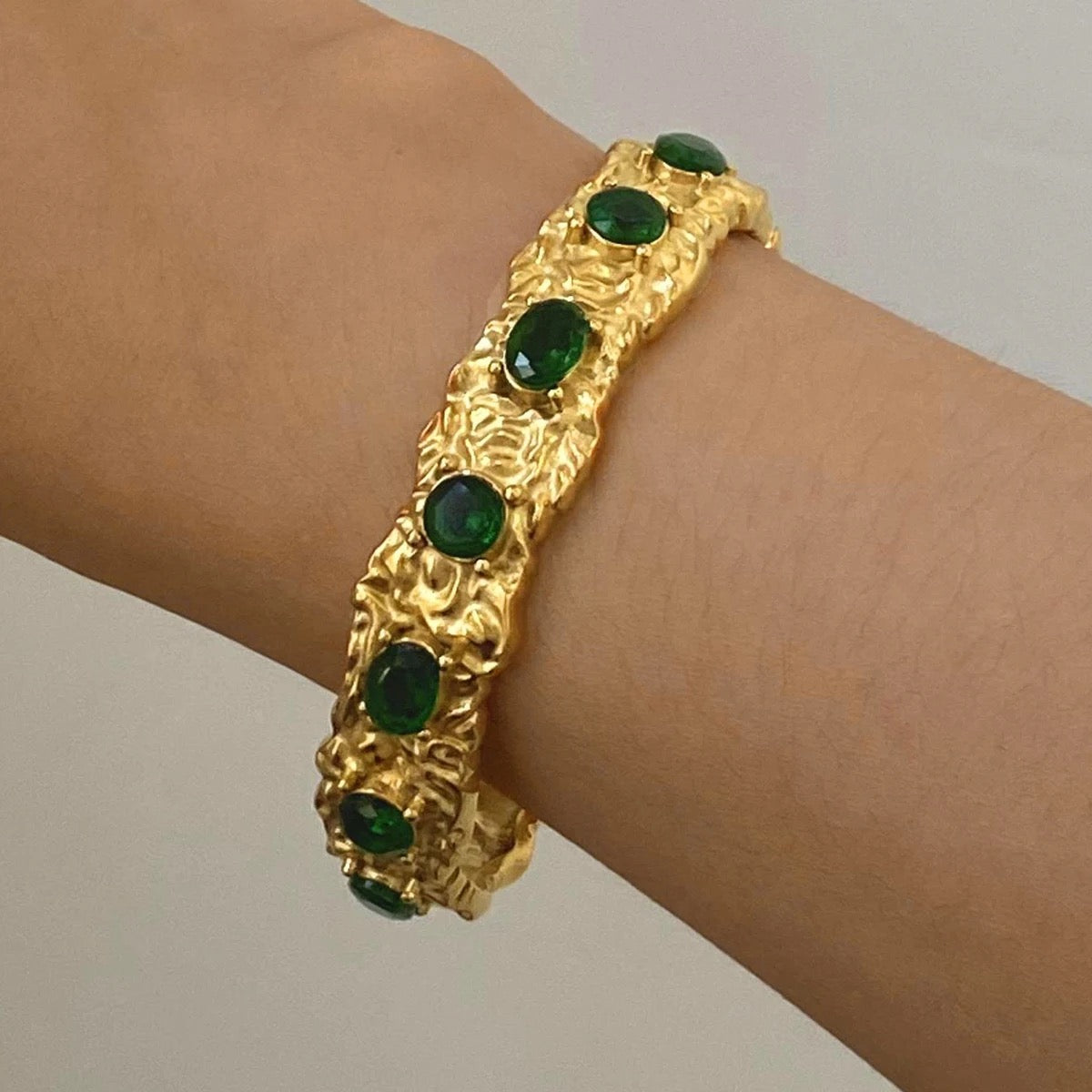 Luxury gold bangle emerald green stone.